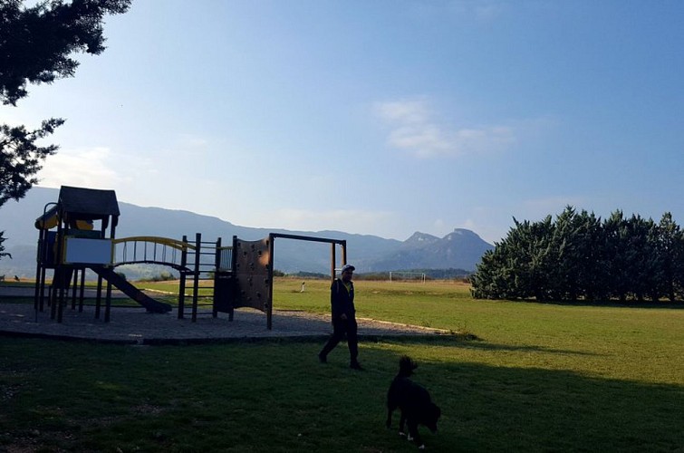 Un espace ludique avec jeux et terrain de basket, avec le Mont Garde en toile de fond