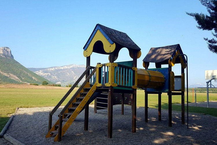 Un espace ludique avec jeux et terrain de basket, avec le Mont Garde en toile de fond