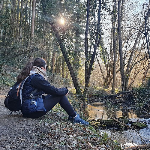 Randonneuse assise au bord de l'eau