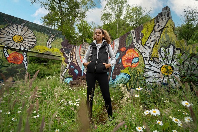 Une femme devant la fresque Symbioses à Gesves