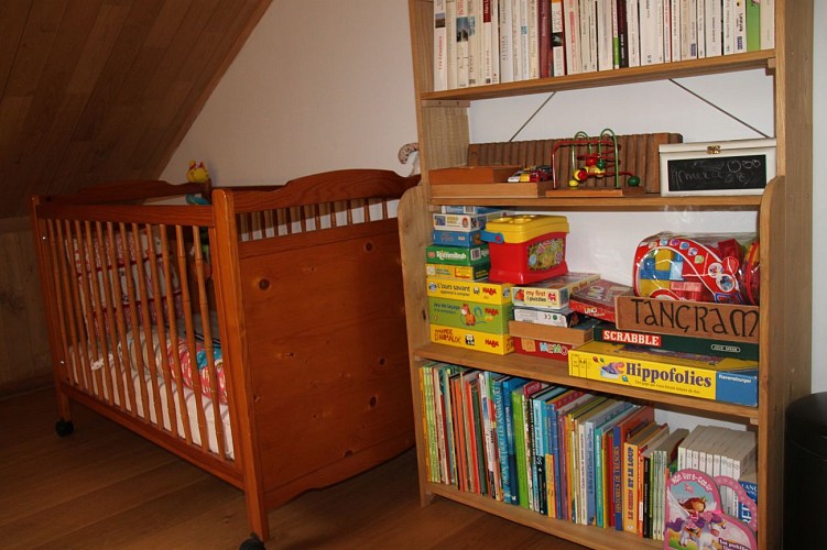 Chambre d'hôtes - Les Prés du Lilot - lit bébé et étagère jeux d'intérieur