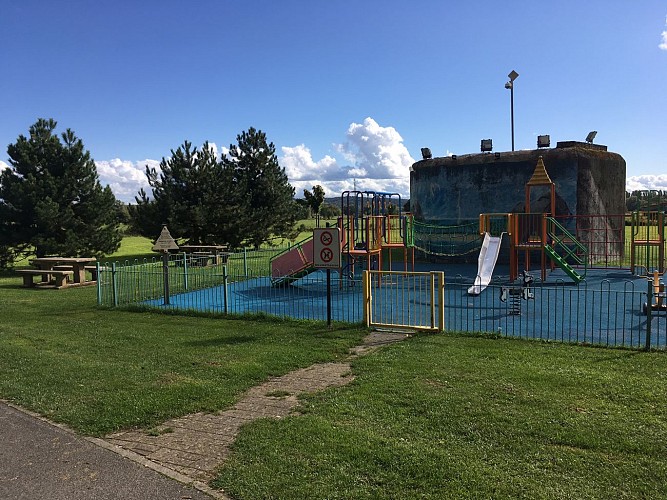 Table de pique-nique à proximité d'une aire de jeux pour enfants et d'un city stade