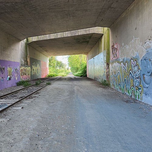 Prendre la voie verte à droite et passer sous le pont