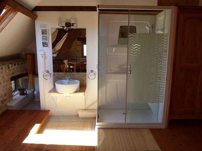 Coin salle de bain ouvert sur la chambre