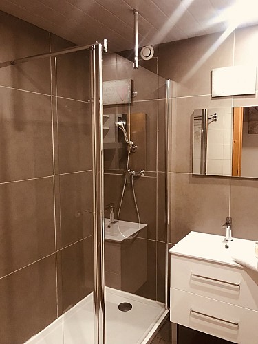 salle de bain avec douche, lavabo sous-vasque, placard de rangement, lave linge