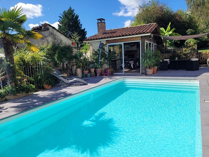 la piscine avec en fond la cuisine d'été du gite Pierre Forte
