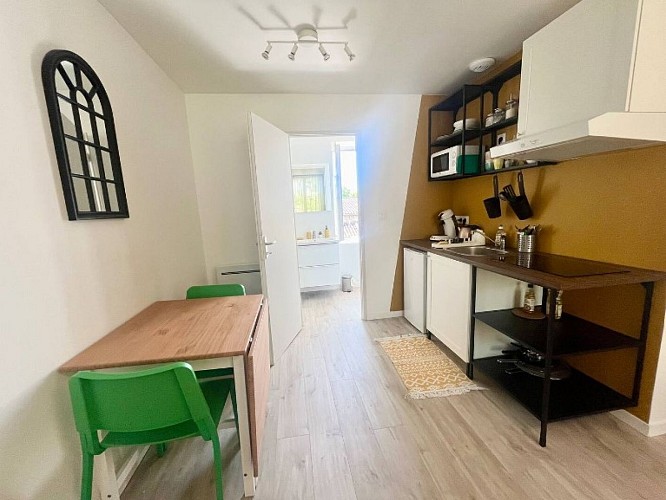 Cuisine avec table extensible, 2 chaises vertes et 2 tabourets