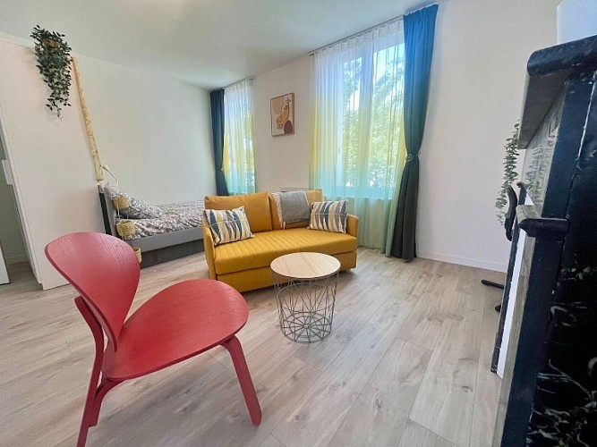 Vue du salon avec fauteuil, canapé convertible et lit deux places