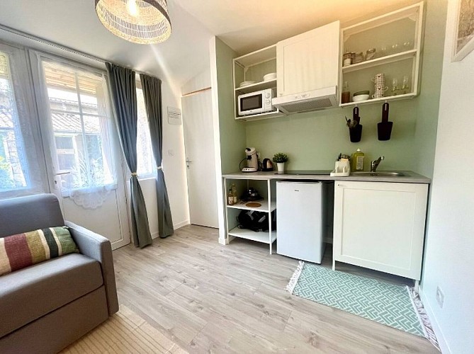 Cuisine ouverte équipée donnant sur la pièce principale