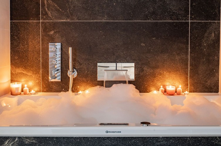 Salle de bain avec baignoire balnéo