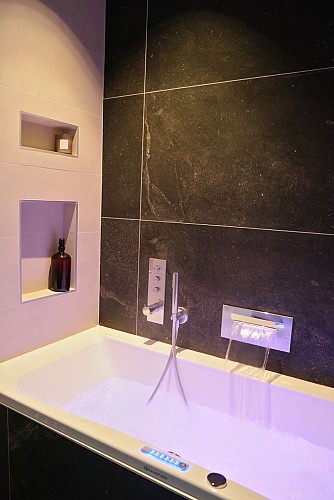 Salle de bain avec baignoire balnéo