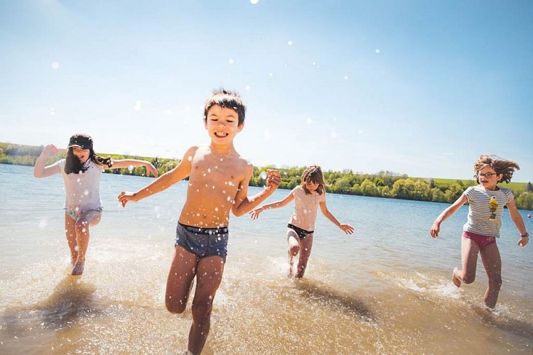 Enfants qui jouent dans l'eau au bordde la plage du Lac de Bairon