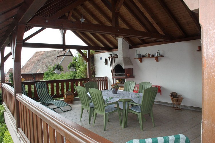 Terrasse couverte avec barbecue et salon de jardin