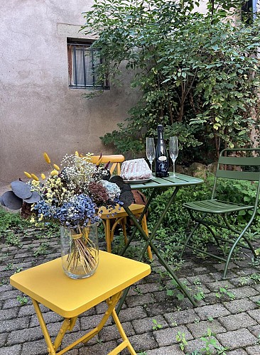 Cour intérieure de l'immeuble commune à 3 gîtes avec table et chaises pour y manger ou se détendre
