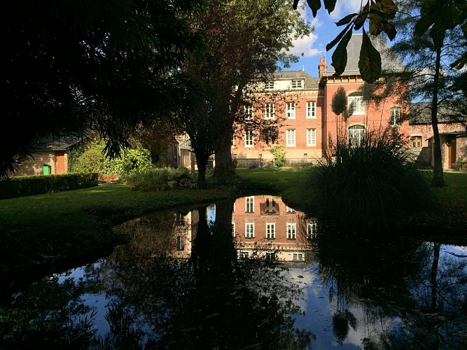 La maison du parc se reflétant dans le plan d'eau