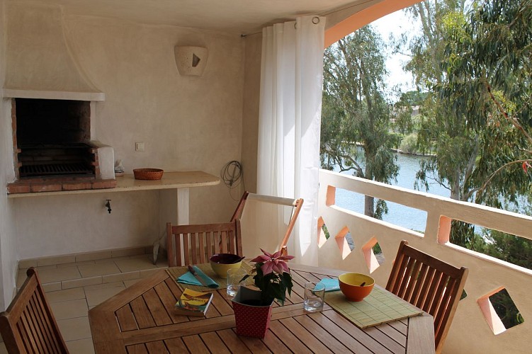Loggia équipée d'un barbecue avec coin repas