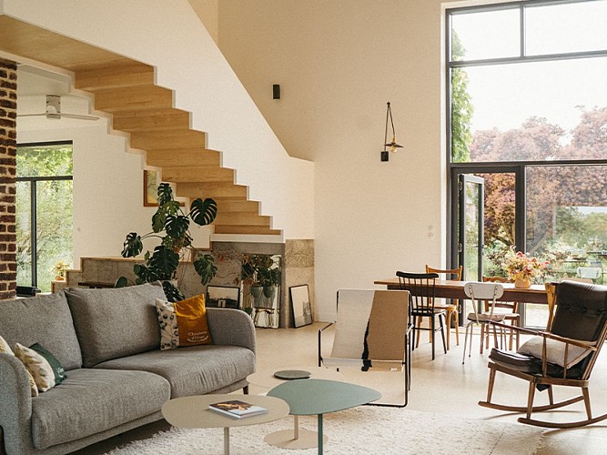 Le salon ouvert sur la nature grâce aux grandes baies vitrées