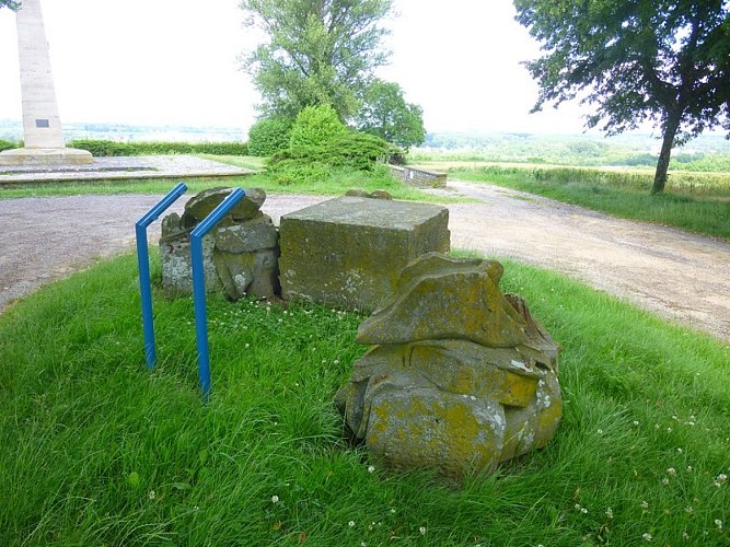 Les vestiges du monument originel. On peut distinguer les coiffes militaires rappelant les conflits.