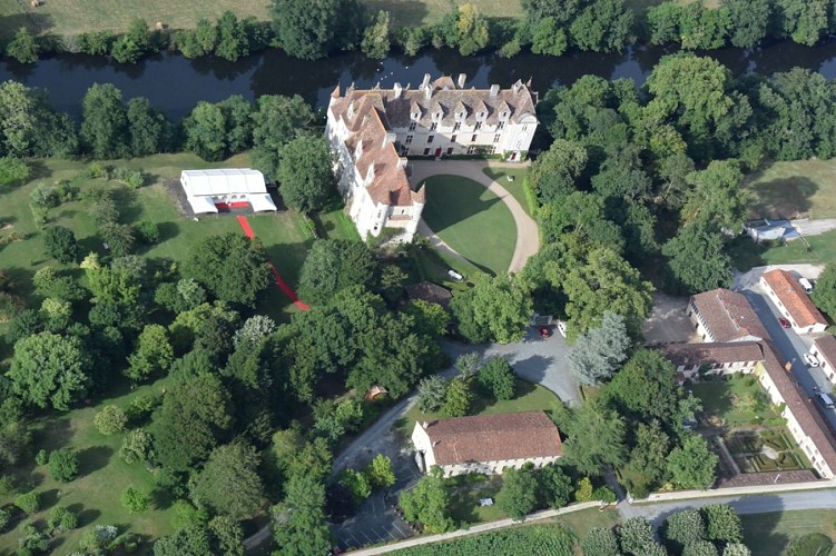le château de Neuvic et le chapiteau de réception dans le parc botanique