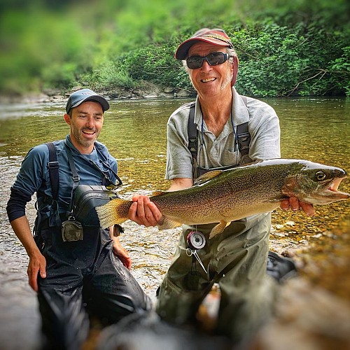 Une grosse truite et un pêcheur heureux